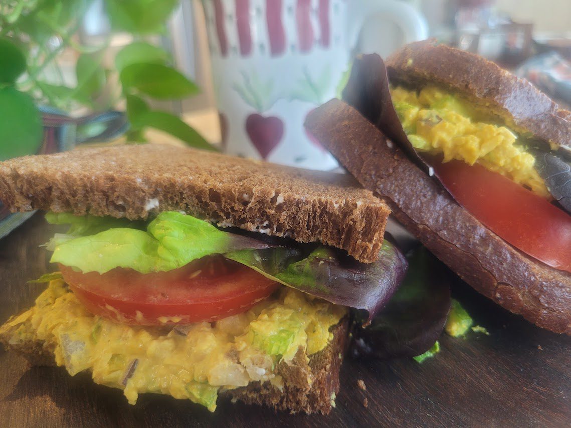 A sandwich with avocado and tomato on it.