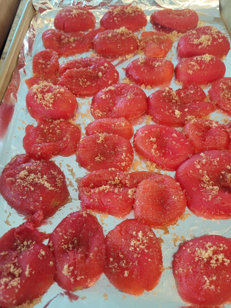 A tray of tomatoes with sesame seeds on top.