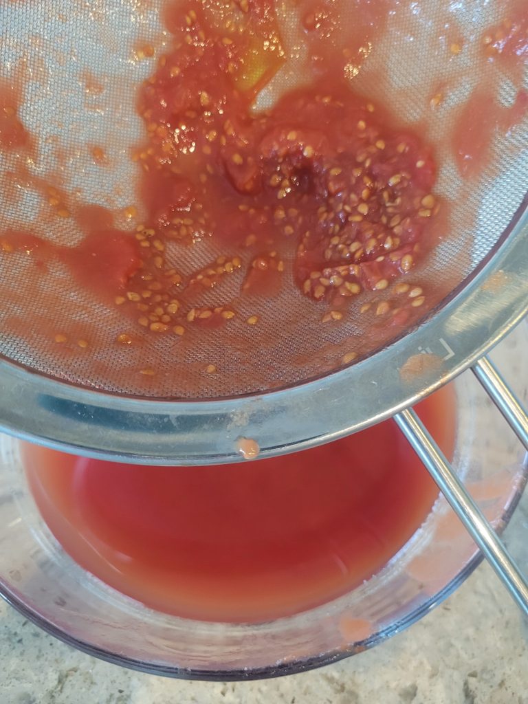 A bowl of tomato sauce is being blended.