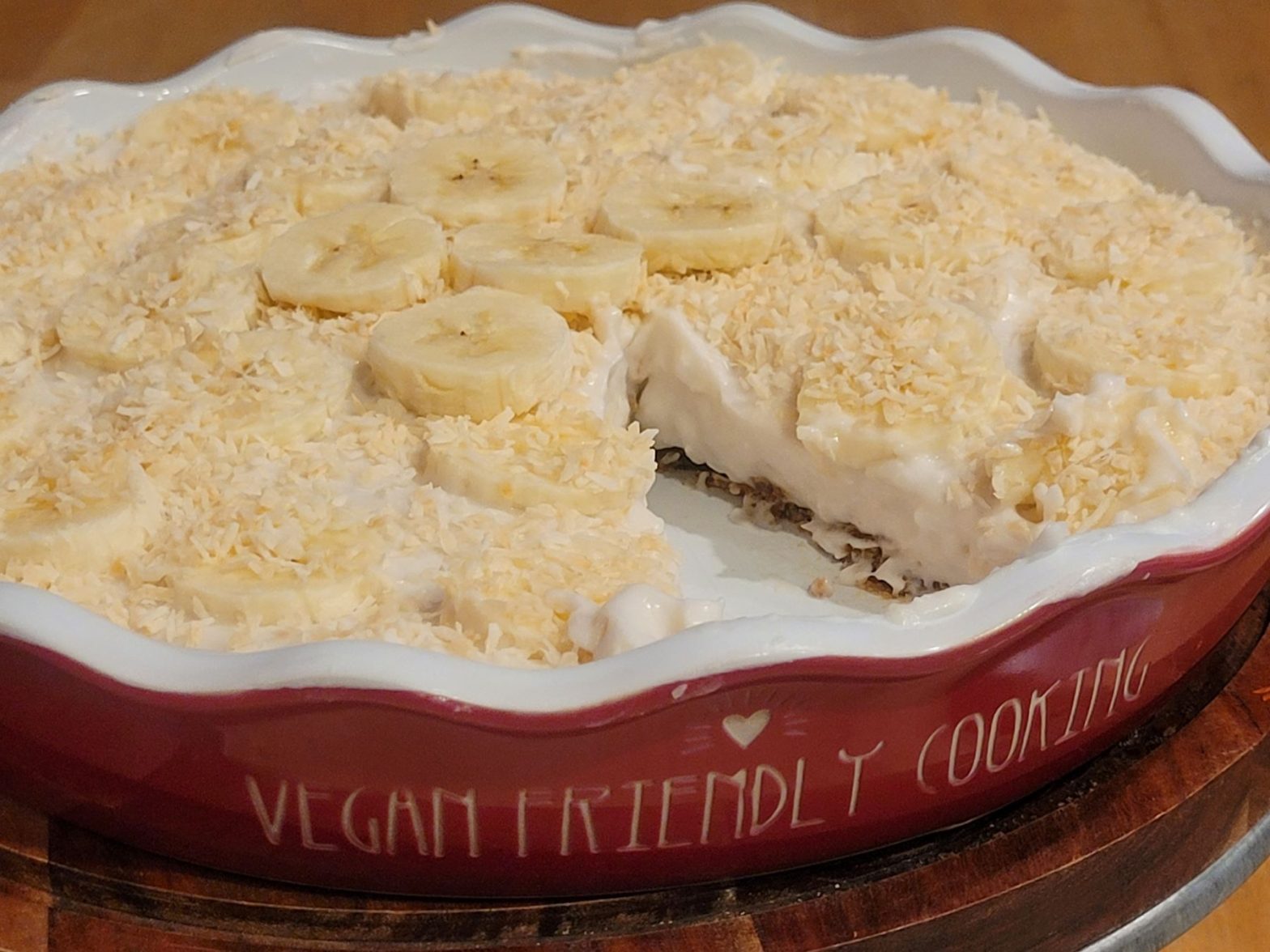 A pie with bananas and coconut on top of it.